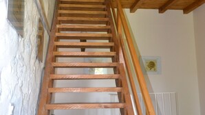 A wooden staircase with a white railing, leading to an upper floor.