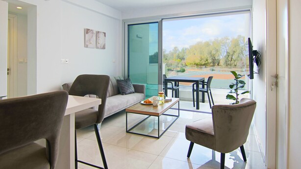 A modern living room with a sofa, armchair, and coffee table. - Phaedrus Living: Seaside Executive Flat Harbour 204 (Paphos)