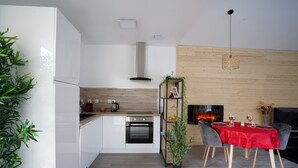 Una cocina moderna con armarios blancos, horno integrado y campana extractora de acero inoxidable.