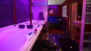 Un cuarto de spa con una bañera grande, una camilla de masaje y una cama pequeña.