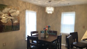 A dining area with a wooden table and chairs, a chandelier, and a painting on the wall. - 1220 Hartford Avenue <br> Previous 4 star owner , Airbnb<br>Happy New Year to All (Atlanta)