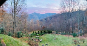 A view of a mountainous landscape with a grassy area and trees.
