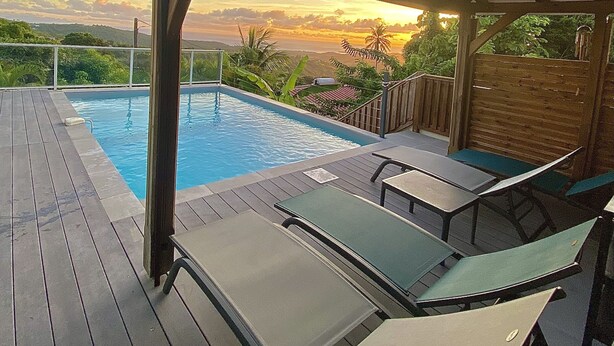 A pool area with lounge chairs and a pergola. - VILLA PAMEYAQUE T3 SUPERB SEA VIEW AND SWIMMING POOL (Rivière-Salée)