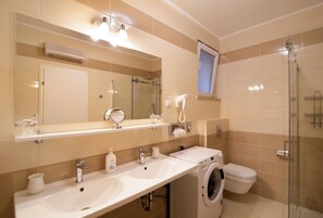 Chuveiro, secador de cabelo, toalhas de banho, sabonete