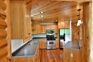 Enjoy cooking in this well-equipped kitchen with a central island, stove, and refrigerator.