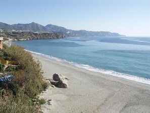 A coastal landscape with a sandy beach, rocky outcrops, and distant mountains. - Apartment in Carabeo near Burriana beach (Nerja)
