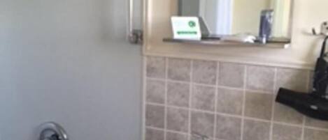 A bathroom with a sink, mirror, and shower curtain.