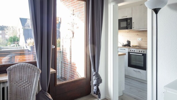 Un apartamento moderno con comedor, cocina y balcón.