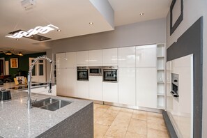 Una cocina moderna con armarios blancos, electrodomésticos de acero inoxidable y encimera de granito.