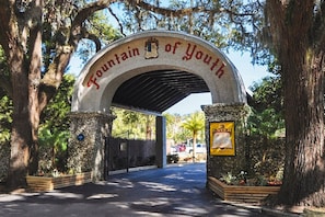 Un arco de entrada con la inscripción 'Fountain of Youth' y un letrero que indica 'ENTER', con una advertencia sobre 'HARD ROCKS' debajo.