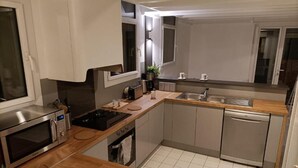 Une cuisine moderne équipée d’un four à micro-ondes, d’une cuisinière, d’un évier et d’un lave-vaisselle.