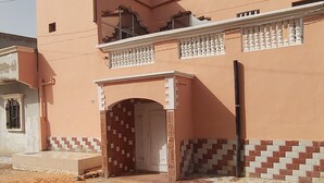 A two-story building with a tiled entrance and a balcony. - Corporate Apartment (Nouakchott)