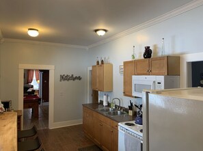 A compact kitchen with wooden cabinets, a microwave, and a sink.
