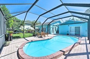 A covered swimming pool with a patio area, a table, and chairs. - NEW! Clean, Cozy Beach home w/Ocean Access, 5Mi to Beach (Bonita Springs)