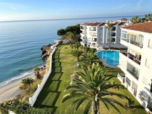 A resort with a pool, beachfront, and ocean view. - Sea-view apartment in Torrecilla (Nerja)