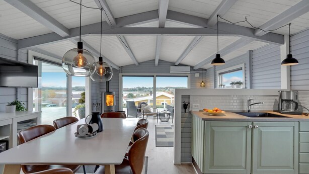 Una cocina moderna con una isla central, ventanas amplias y un comedor con vistas.