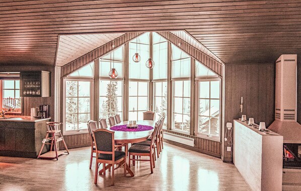 Enjoy meals in this dining area with a high ceiling and large windows offering views of the surrounding landscape.