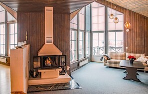 Cozy space with a stove, large windows, and a comfortable seating area.