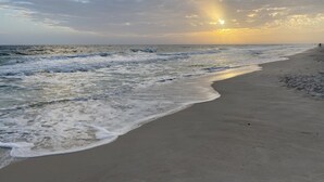 Una playa con olas y un atardecer.