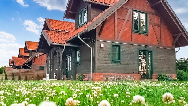 A traditional wooden house with a sloped roof and a well-maintained garden in front. - Lovely home in Gizycko with WiFi (Gizycko)