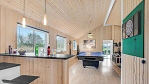 Un intérieur moderne avec des murs recouverts de panneaux de bois, une table de ping-pong et un jeu de fléchettes.