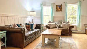 Un salon chaleureux avec deux canapés en cuir, une table basse en bois et un tapis à motifs.