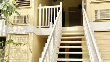 A two-story building with a white staircase leading to a balcony.