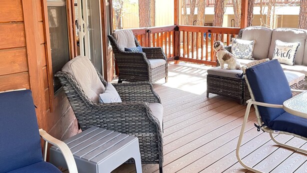 A covered outdoor deck with wicker furniture and a small table. - Relaxing 3 bedroom retreat in the pines , come relax in tranquility,<br>  (Pinetop)