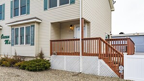 A two-story house with a wooden deck and a mailbox. - Seaside Park 3BR Beach Home – Family-Friendly, Walk to Beach + Peloton + Badges (Seaside Park)
