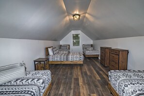 A loft bedroom with a sloped ceiling, two beds with patterned bedding, a wooden dresser, and a small table. - 4Bedrooms+BonusRoom Firepit Hottub Linens   Golf Casino Camelback SKI Mts! (Cresco)
