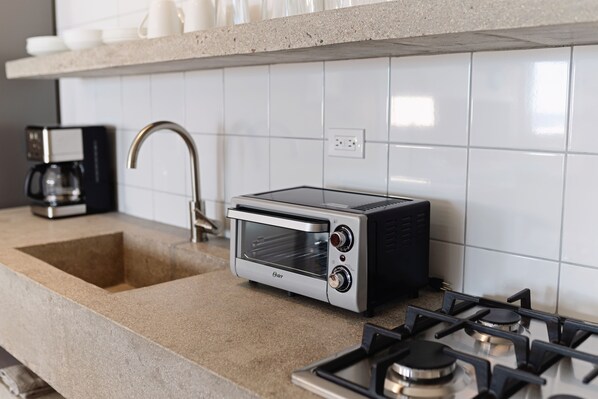 A kitchen with a built-in toaster oven, a sink, and a coffee maker. - Surf Suite Sur at Topia All-Incl 250pp Meals Incl (El Pescadero)