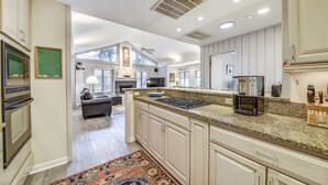 A spacious kitchen with granite countertops, a built-in oven, and a large island with a coffee maker. - Charming Sea Pines Retreat – 4th Row from the Beach with EV Charger (Hilton Head Island)