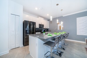 Enjoy cooking in this well-lit kitchen with a central island and stainless steel appliances.