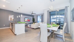 Eine moderne Küche mit weißen Schränken, einer zentralen Kochinsel und Pendelleuchten.