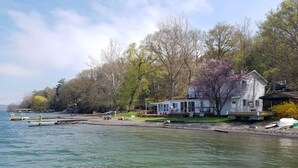 A lakeside property with a dock, a house with a deck, and a boat. - Rustic-chic cottage with fantastic lake access, 15 minutes to Ithaca (Ithaca)