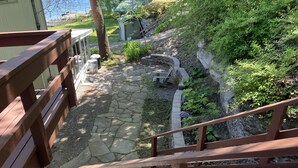A wooden staircase leading to a stone pathway with a bench and a small garden area. - Rustic-chic cottage with fantastic lake access, 15 minutes to Ithaca (Ithaca)