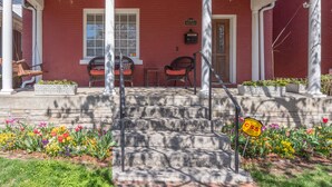 A red brick building with a porch, two wicker chairs, and a small table. - Nashville Historic Edgehill/Music Row/ Gulch Home (Nashville)