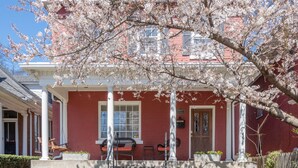 A red brick house with a white porch, stone steps, and a cherry blossom tree. - Nashville Historic Edgehill/Music Row/ Gulch Home (Nashville)