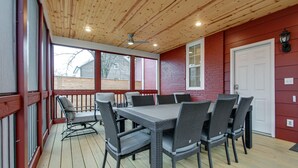 A covered patio with a wooden ceiling, a red brick wall, and a white door. - Nashville Historic Edgehill/Music Row/ Gulch Home (Nashville)