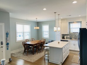 Enjoy meals in the kitchen and dining area with an island and chandelier.