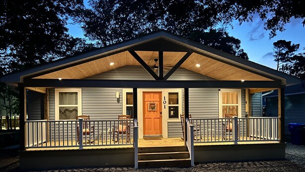 A small, single-story cabin with a porch, a front door, and a number "101" on the door. - The Inkwell ~ An Oak Island Gem (Oak Island)