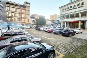 A parking lot with multiple cars parked in front of a hotel.