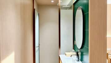 A bathroom with a wooden door, a mirror, and a sink.