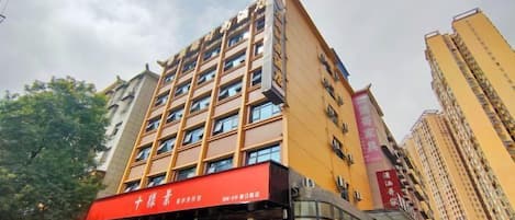 A multi-story hotel with a red awning and signage indicating it is a hotel.