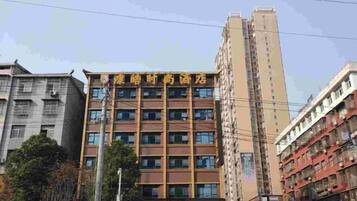 A multi-story hotel with a modern facade, featuring a series of windows and balconies.