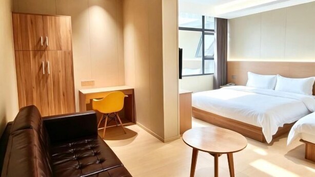 Een moderne hotelkamer met een bed, een bank, een bureau en een stoel.