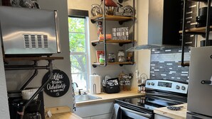 Een moderne keuken met roestvrijstalen apparatuur, houten aanrecht en een zwarte prullenbak.