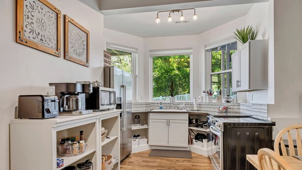 A modern kitchen with white cabinetry, a built-in oven, and a coffee machine. - Mountain View Retreat: 2 BR/2 BA Spacious & Cozy! (Bountiful)