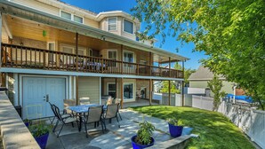 A two-story residential building with a balcony, a patio with outdoor furniture, and a well-maintained lawn. - Mountain View Retreat: 2 BR/2 BA Spacious & Cozy! (Bountiful)