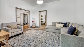 A spacious living room with two grey sofas, a patterned rug, and a hanging light fixture. - Mountain View Retreat: 2 BR/2 BA Spacious & Cozy! (Bountiful)